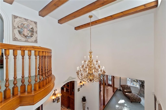 interior space with beamed ceiling and a chandelier