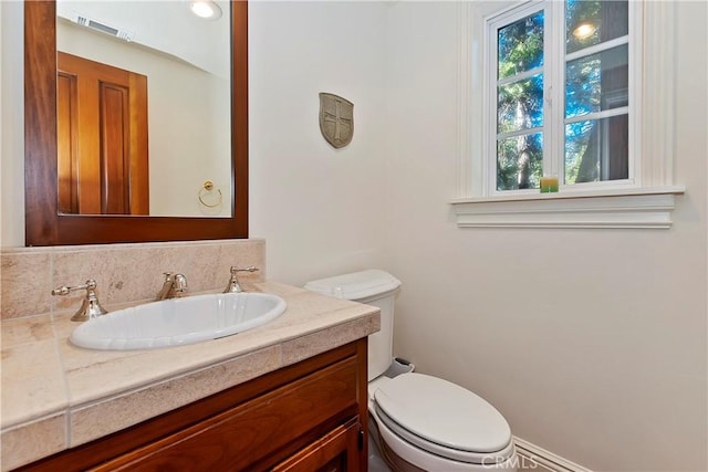 bathroom featuring tasteful backsplash, vanity, and toilet