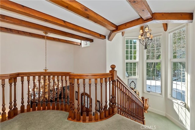 stairway featuring beamed ceiling, a chandelier, and carpet