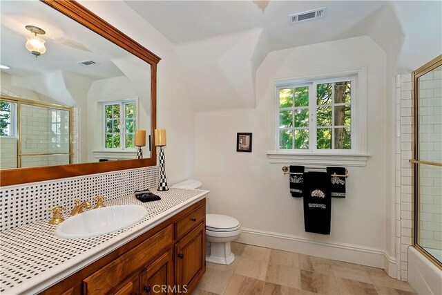 29223 Pigeon Hawk Ln, Lake Arrowhead, CA 92352 - bathroom with vanity, vaulted ceiling, tasteful backsplash, and enclosed tub / shower combo