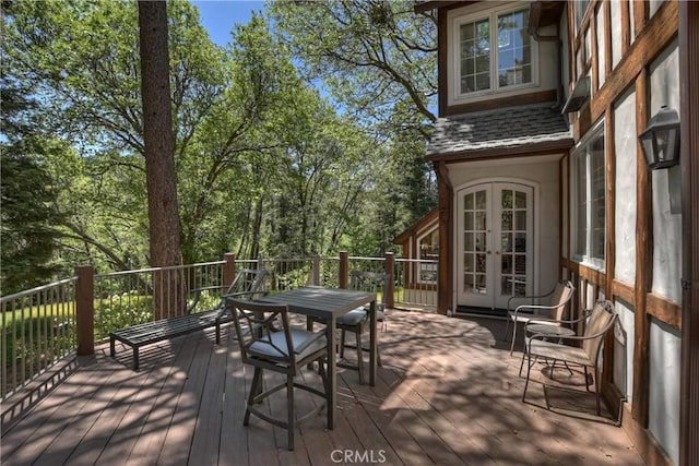 29223 Pigeon Hawk Ln, Lake Arrowhead, CA 92352 - wooden deck with french doors, outdoor dining area, and view of wooded area