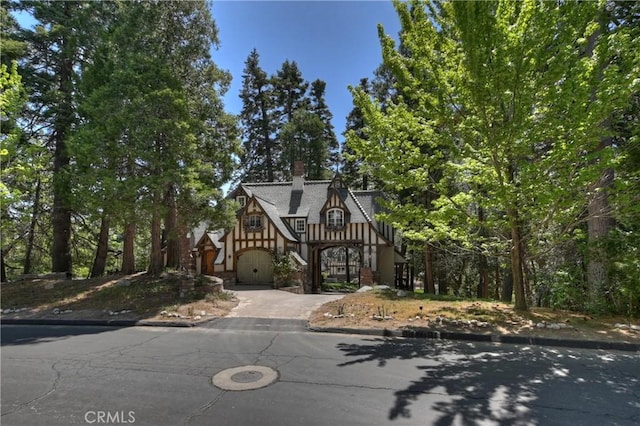 29223 Pigeon Hawk Ln, Lake Arrowhead, CA 92352 - english style home featuring stairway, driveway, a chimney, and a garage