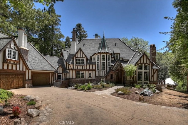 29223 Pigeon Hawk Ln, Lake Arrowhead, CA 92352 - view of front of house featuring stucco siding, concrete driveway, stone siding, and a chimney