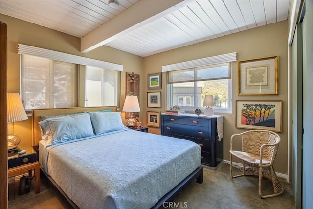 bedroom with wooden ceiling, beam ceiling, and dark colored carpet