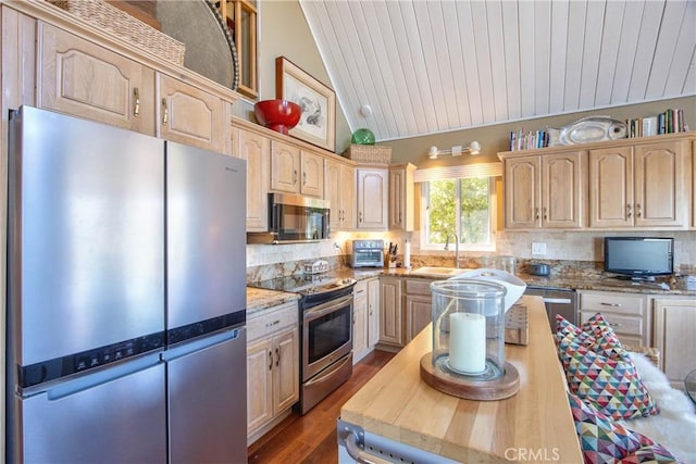 kitchen with lofted ceiling, sink, light brown cabinets, appliances with stainless steel finishes, and light stone countertops