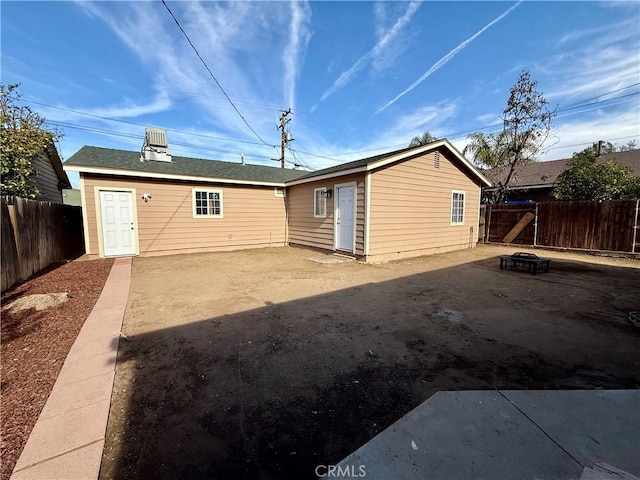 back of house with a fire pit