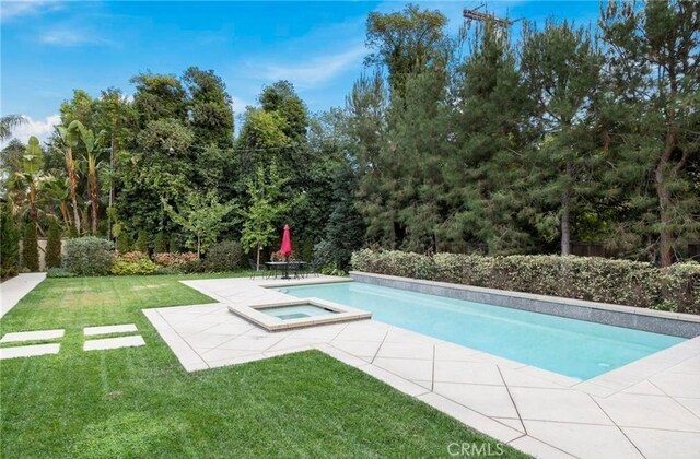 pool with an in ground hot tub, a yard, and a patio