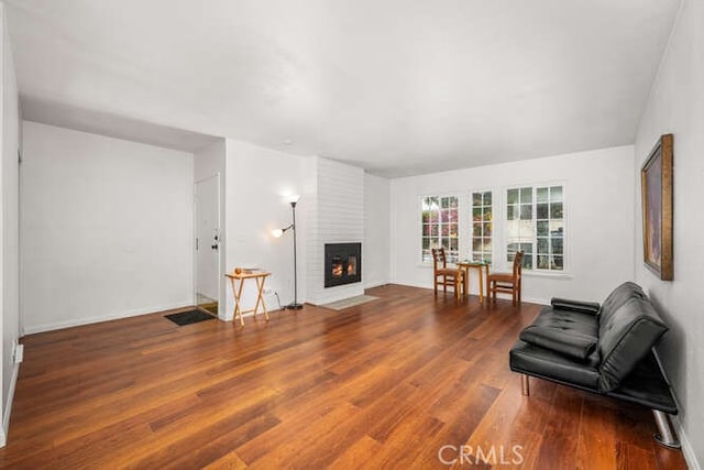 living room with hardwood / wood-style floors and a large fireplace