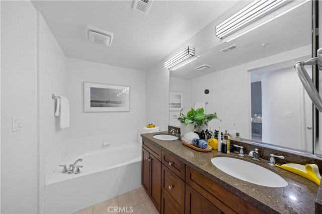 bathroom featuring vanity, tile patterned floors, and a tub to relax in