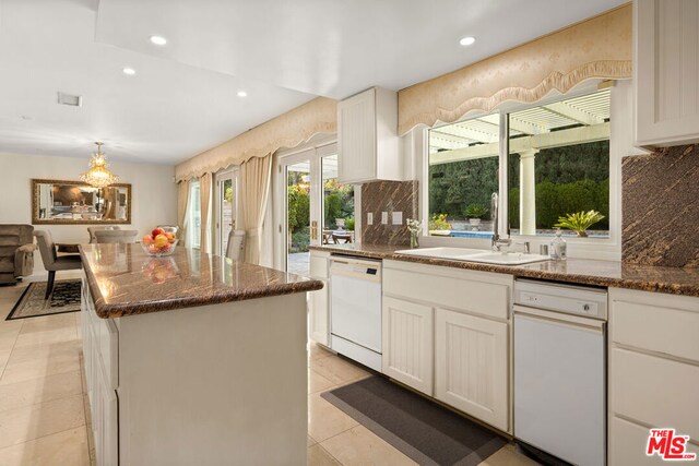 kitchen featuring white cabinets, dark stone counters, dishwasher, and a kitchen island