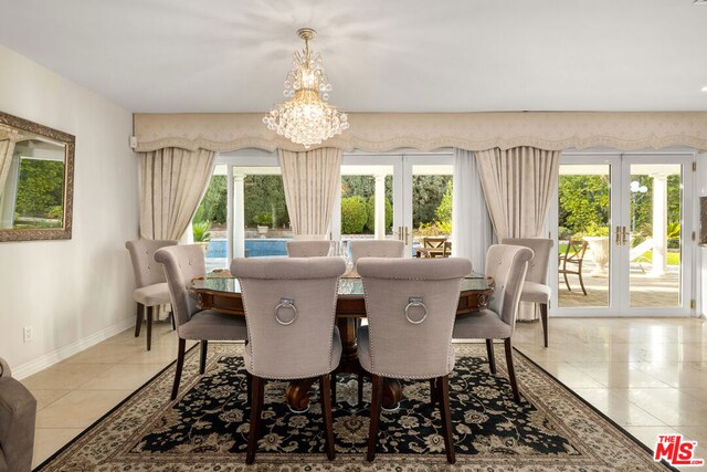 tiled dining space featuring plenty of natural light, a chandelier, and french doors