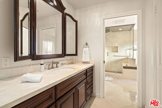 bathroom featuring vanity, tile patterned flooring, and a shower with door