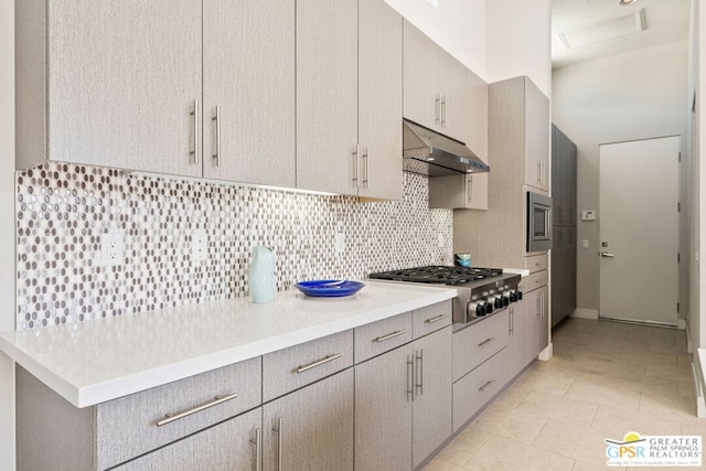 kitchen featuring backsplash, light tile patterned floors, and stainless steel appliances