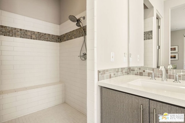 bathroom with tiled shower and vanity