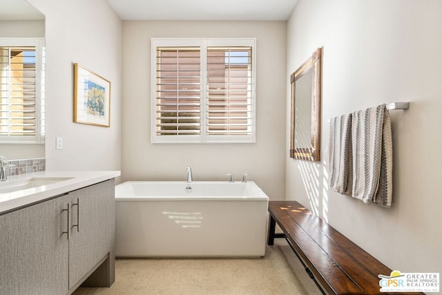 bathroom featuring vanity, a bathtub, and a wealth of natural light