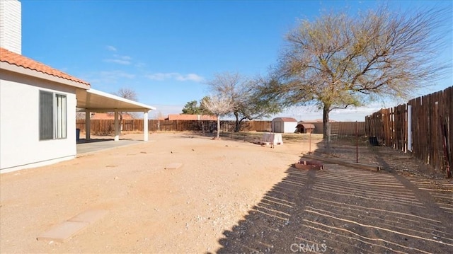 view of yard with a storage unit and a patio