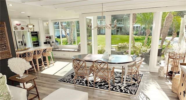 sunroom / solarium featuring a notable chandelier