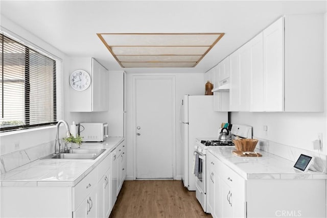 kitchen featuring white cabinetry, white appliances, light hardwood / wood-style floors, and sink