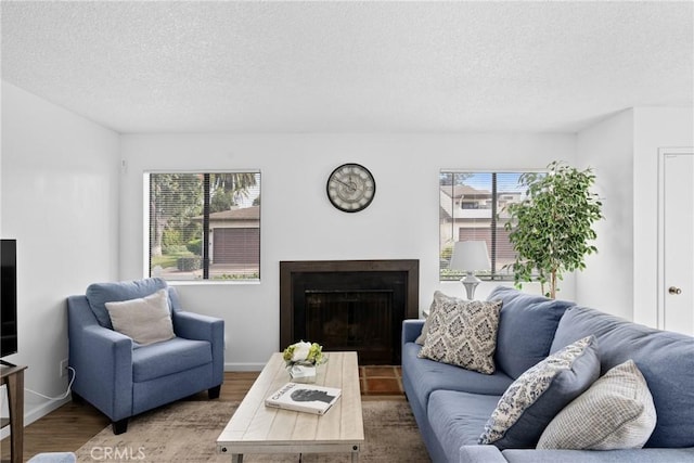 living room with a healthy amount of sunlight, hardwood / wood-style floors, and a textured ceiling