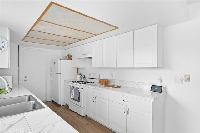 kitchen with sink, white cabinetry, wood-type flooring, white appliances, and light stone countertops