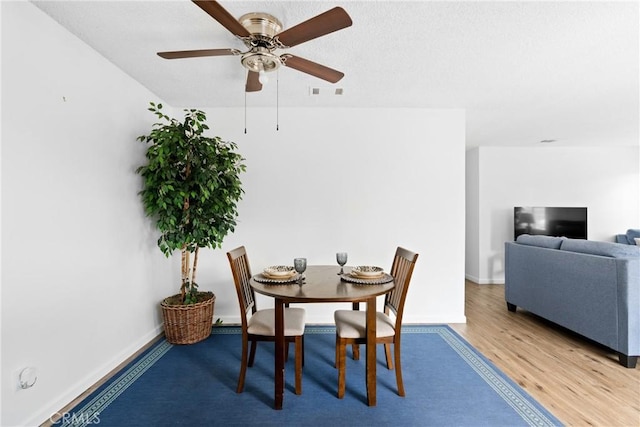 dining area with ceiling fan and light wood-type flooring