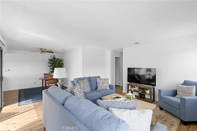 living room with hardwood / wood-style flooring and ceiling fan