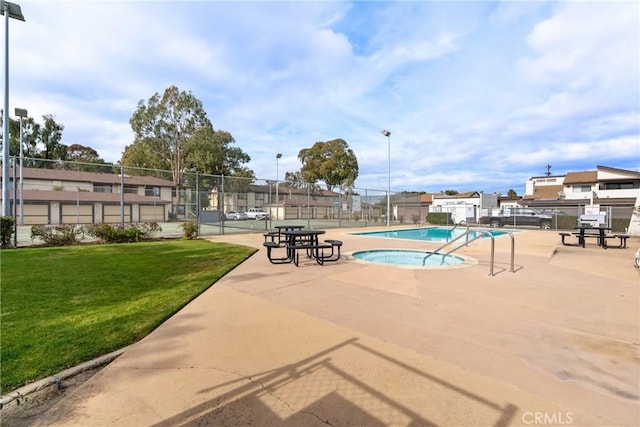 view of swimming pool featuring a community hot tub and a lawn