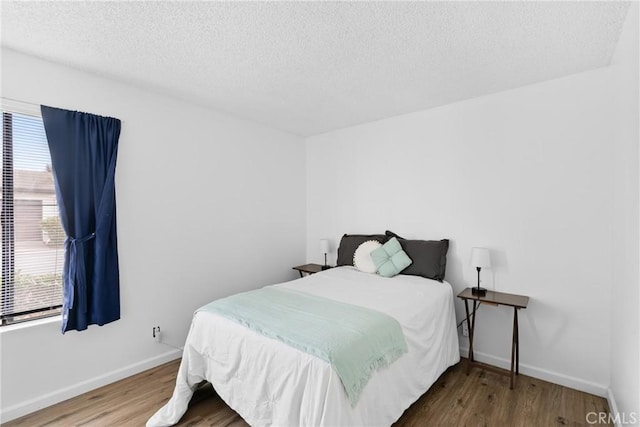 bedroom featuring hardwood / wood-style flooring and a textured ceiling