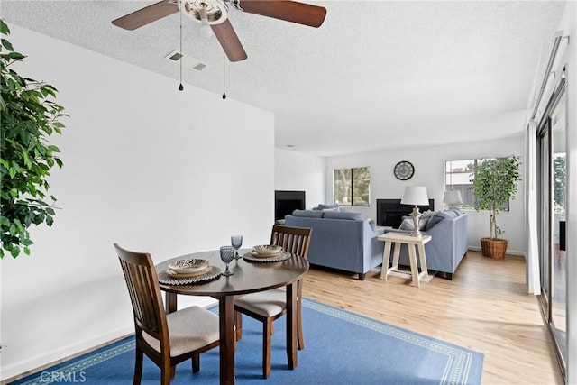 dining space featuring light hardwood / wood-style floors and a textured ceiling