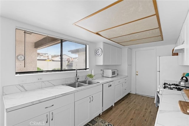 kitchen featuring white cabinetry, sink, white appliances, and ventilation hood