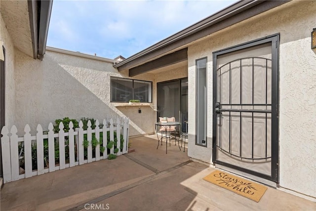 view of exterior entry with a patio