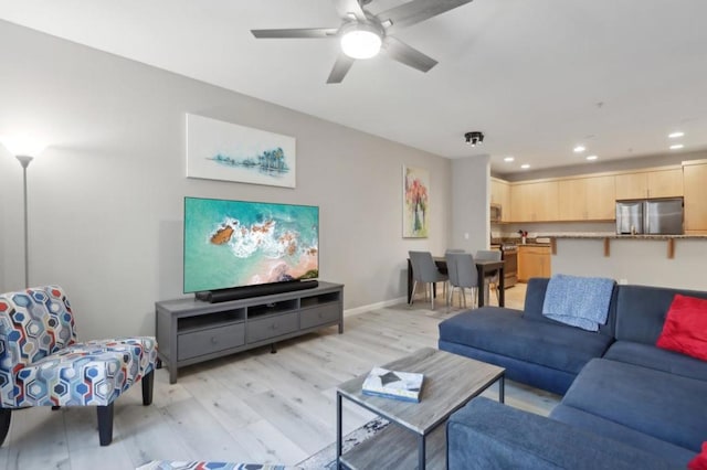 living room featuring light hardwood / wood-style floors and ceiling fan