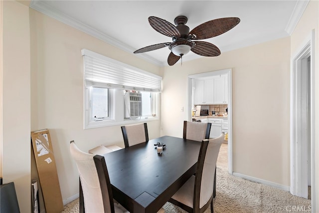 carpeted dining area with ceiling fan and ornamental molding