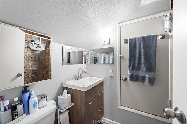 bathroom with vanity, a textured ceiling, and toilet