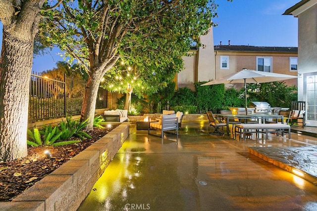 patio terrace at dusk with an outdoor living space and grilling area