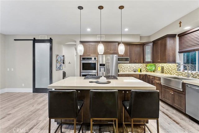 kitchen with a kitchen island, appliances with stainless steel finishes, and a kitchen breakfast bar