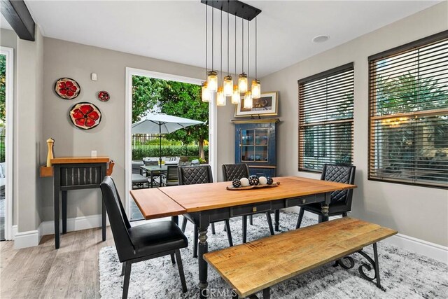 dining space with light wood-type flooring and baseboards