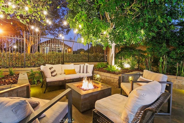 patio at twilight featuring an outdoor living space with a fire pit