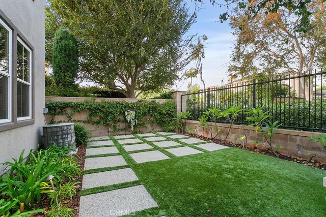 view of yard with central AC, a patio area, and a fenced backyard