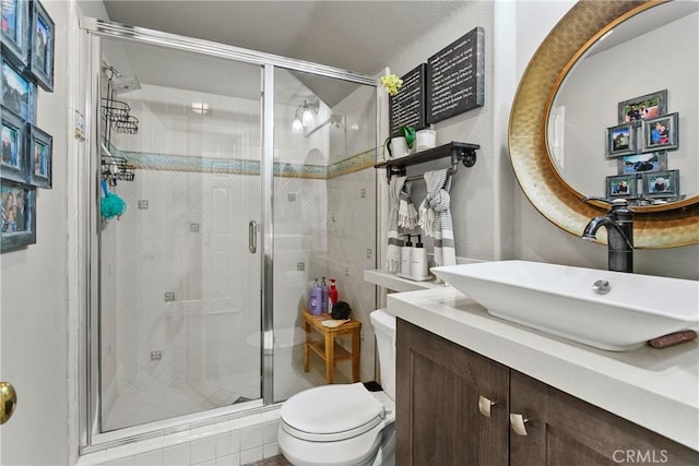 bathroom with vanity, toilet, and a shower with door