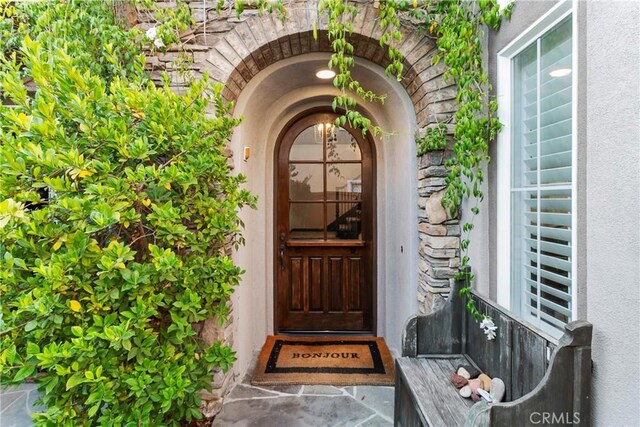 doorway to property featuring stucco siding