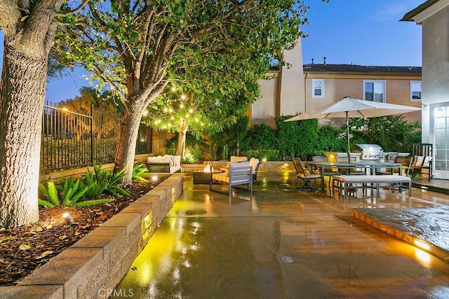 patio terrace at dusk with area for grilling and an outdoor hangout area