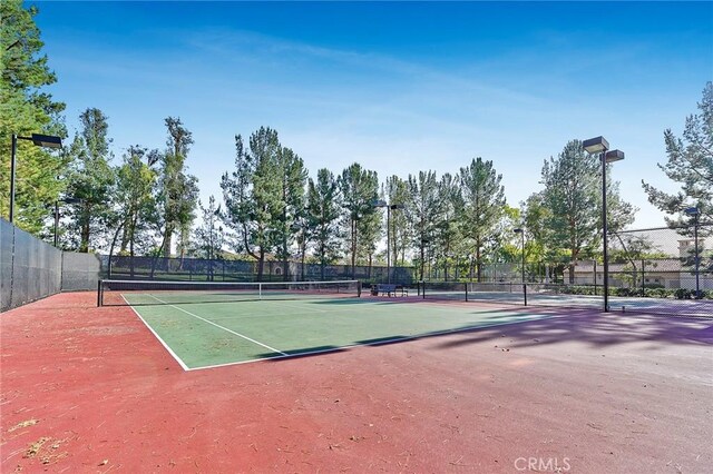 view of tennis court featuring fence