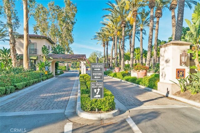 view of street featuring a gated entry and curbs