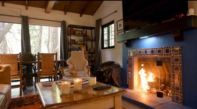 sitting room featuring a fireplace, lofted ceiling with beams, and wooden ceiling