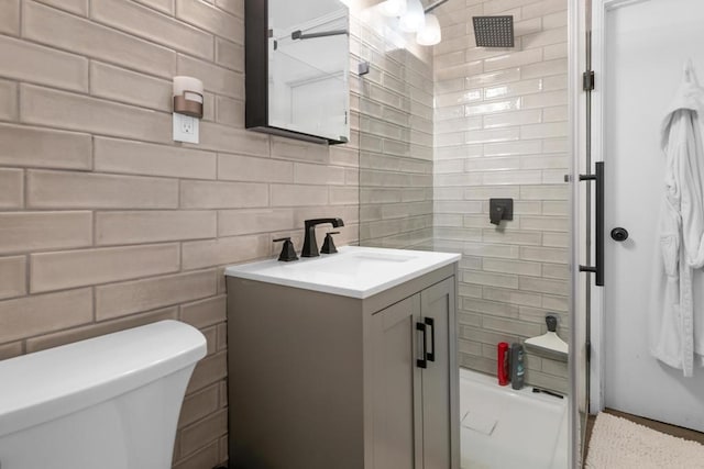 bathroom featuring vanity, tile walls, walk in shower, and toilet