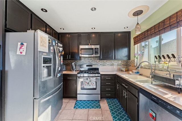 kitchen featuring stainless steel appliances, a sink, light countertops, and decorative backsplash