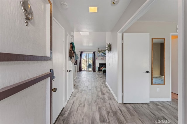 hallway featuring wood finished floors and baseboards