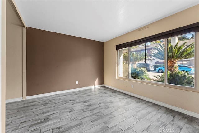 empty room featuring baseboards and wood finished floors