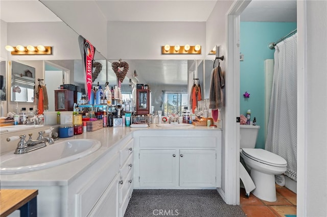 bathroom featuring double vanity, a shower with shower curtain, a sink, and toilet